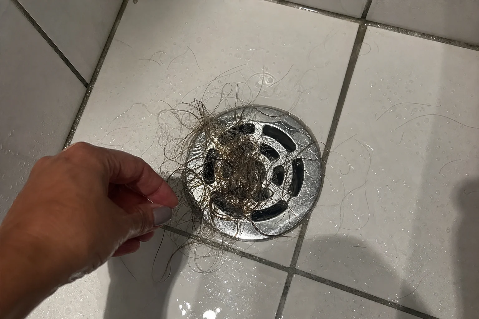 Duschabfluss mit einer Handvoll Haare